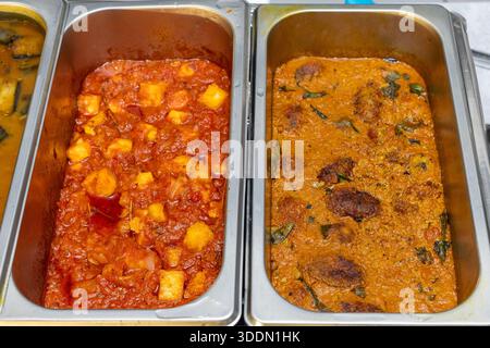 Two delicious Indian curries served in metal catering pans, ready for a buffet Stock Photo