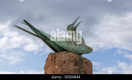 Metal seagull sculpture on a small rock in North Berwick, Scotland, photographed from below against the sky. Stock Photo