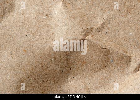 Close-up view of crumpled brown paper showcasing its unique textures and fibers. Stock Photo