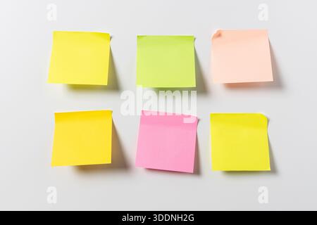 Six blank colorful sticky notes on white wall. Template mock up Stock Photo