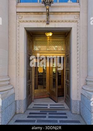 Bronze revolving doors set in ornate limestone faced vestibule of 1926 Beaux-Arts classical First National Bank and Trust downtown Marquette Michigan Stock Photo