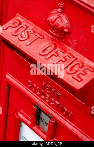 Vintage post office red posting box with George cipher, Kings crown post office postal box close-up. Stock Photo