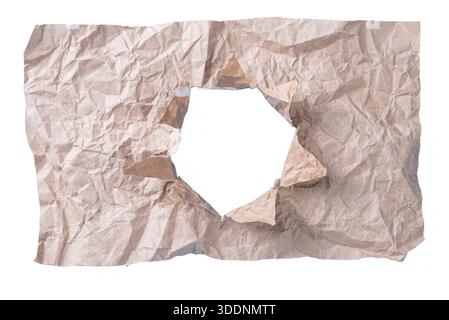 Crumpled brown paper with irregular torn hole isolated on white, dramatic ripped texture for reveal concepts. Stock Photo