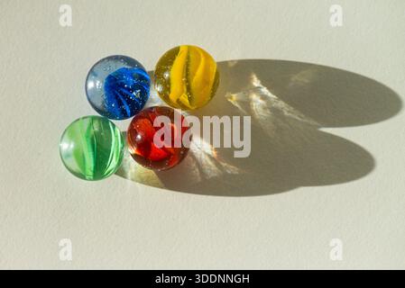 The overhead view of a red, green, yellow and blue cat's eyes marbles Stock Photo