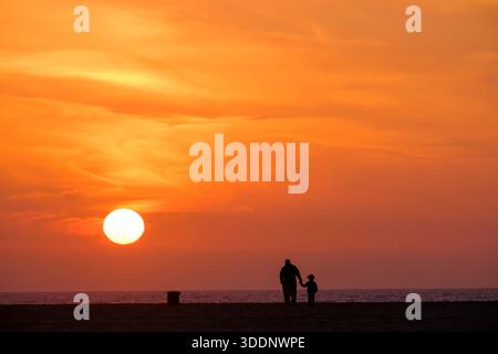 A father and son watching the sunset. Venice Beach, Los Angeles, California, USA Stock Photo