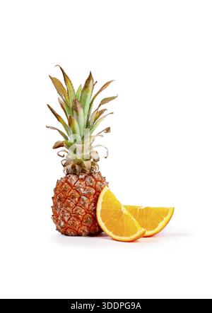 Fresh pineapple and orange slices arranged on a white background, vertical, no people Stock Photo
