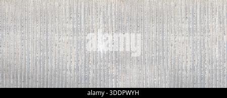 Gray concrete wall with a rough, textured surface and distinct vertical stripes Stock Photo