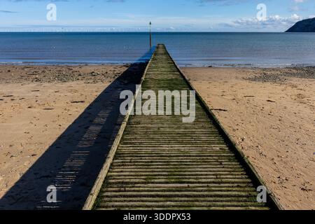 Wooden jetty extending into the sea at Llandudno Stock Photo