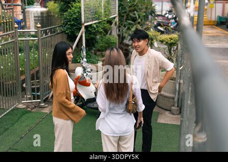 Diverse group of young asian adults discussing outdoors, sharing ideas and building connections Stock Photo