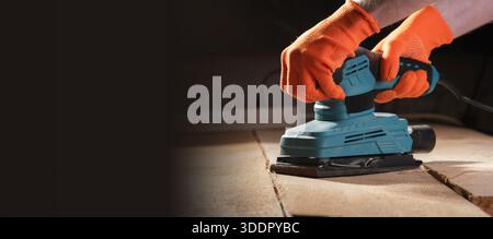 Close-up of male hands using with sander machine on construction Stock Photo
