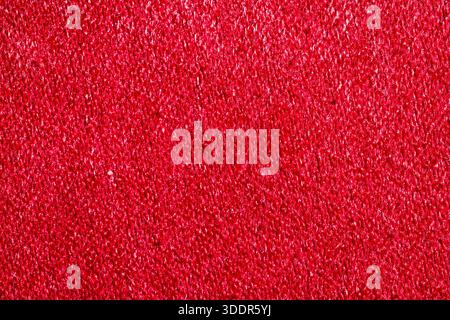 Extreme close-up of vibrant red fabric. Detailed soft textile surface and fiber pattern for fashion, upholstery, and luxury design. Stock Photo