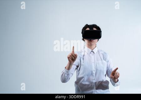 Woman wearing virtual reality headset and selecting digital elements with finger using futuristic human computer interaction technology Stock Photo