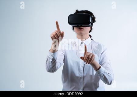 Woman designing virtual reality interface using hand gestures while working in immersive VR design environment on clean white background Stock Photo