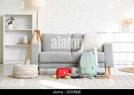 Emergency backpack with necessities on carpet in living room interior Stock Photo