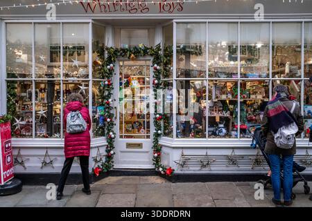 People Look Into The Window Of A Toy Shop In Canterbury At Christmas Time, Canterbury, Kent, UK. Stock Photo