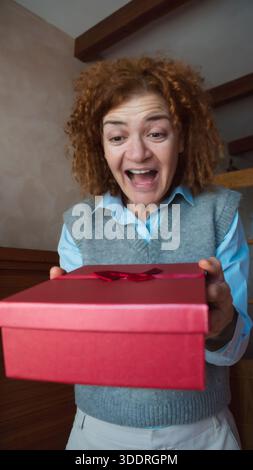Woman expressing surprise receiving a red gift box Stock Photo