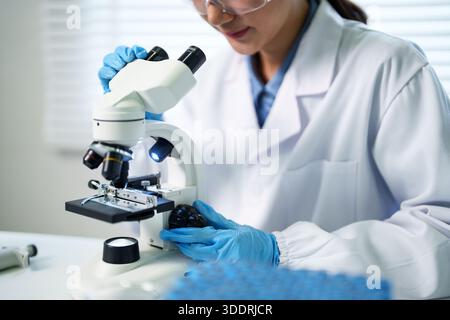 Female scientist works diligently in laboratory. Focus concentrated professional performs detailed analysis experiment developing new solutions. Stock Photo