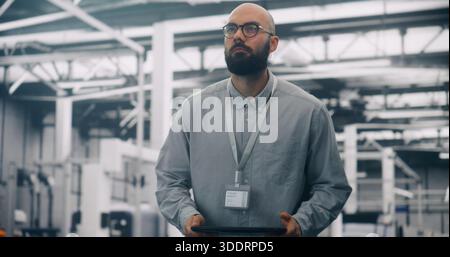 Data Analysis, Engineer Auditing Infrastructure With Digital Tablet. Serious Male IT Engineer Auditing Systems in Large, Modern Data Center. Data Inte Stock Photo