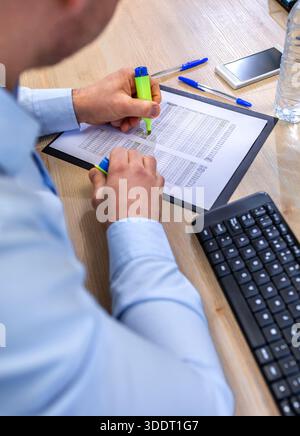 Close up of unrecognizable accountant man hands analyzing data spreadsheet on desk Stock Photo