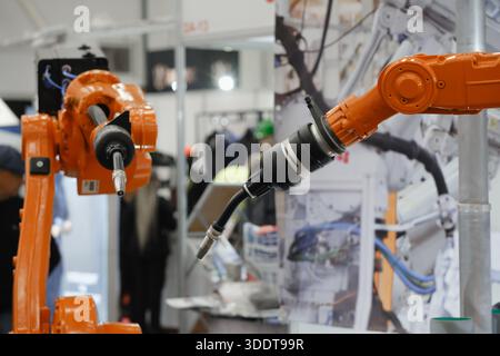 Industrial robotic arms with interchangeable end effectors performing automated welding, cutting, painting, and assembly tasks in advanced Stock Photo