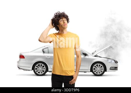 Confused young man with a broken down car isolated on white background Stock Photo