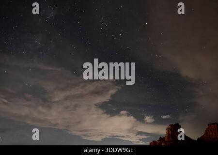 Star field above clouds and desert rock formations in Sedona, Arizona, USA night astrophotography view with wide angle sky and dark silhouettes below. Stock Photo