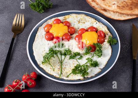 Scrambled eggs with cherry tomatoes in shape of flower - children's breakfast idea Stock Photo
