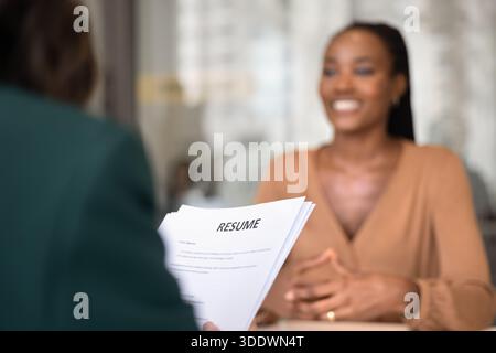 Cropped shot of interviewer woman holding paper resume Stock Photo