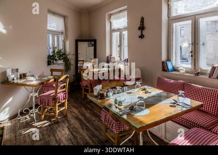 The dining room of the Tık Tık Kadın Emeği ("Women's Labour") restaurant in Ürgüp, Turkey, is furnished with red-checked upholstery and lace curtains. Founded in 2018, the women's cooperative funds scholarships for around 50 female students with its proceeds and was named a Michelin Guide "Recommended Restaurant" in 2026. Stock Photo
