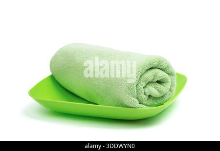 A green folded towel  on a light background, providing a mockup with space for design and branding elements. Stock Photo