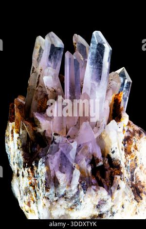Natural amethyst quartz cluster featuring violet transparent crystals emerging from earthy matrix symbolizing clarity energy and spiritual harmony. Stock Photo