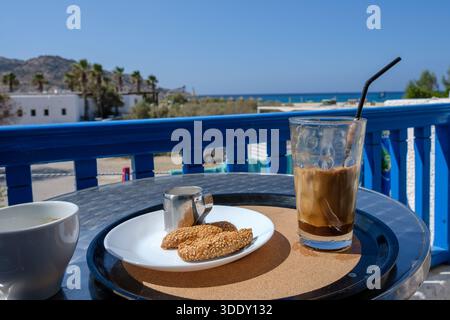 Having a Greek iced frappé coffee and Greek delicious cookies on the balcony in Ios Greece Stock Photo