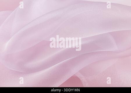 Chic large air waves of white organza on a pink background. stylish wedding background. light airy silk. shine of the fabric. Stock Photo