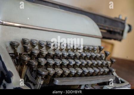 Close up view of vintage mechanical typewriter keys showing worn metal details and classic office equipment design. Stock Photo