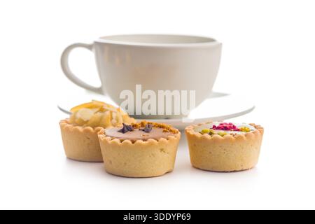 Sweet mini tartlets and coffee cup isolated on a white background. Stock Photo