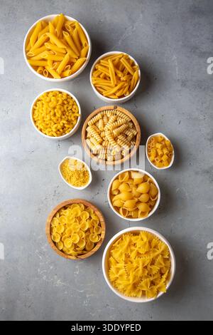 Composition with different tasty uncooked pasta - Italian pasta wallpaper, different types and shapes of pasta layout Stock Photo