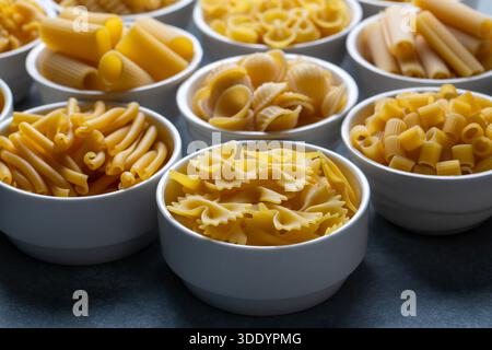 Composition with different tasty uncooked pasta - Italian pasta wallpaper, different types and shapes of pasta layout Stock Photo