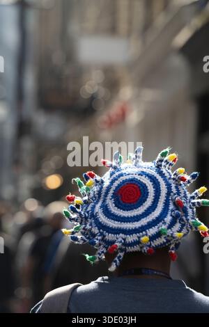 A person wears a colorful, crocheted hat Stock Photo