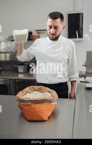 Bread Maker Prepares Sourdough, Skilled Baker Combines Flour Into Proofing Basket For Starter Stock Photo