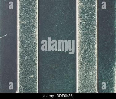 old used dark teal plastic phone back cover in close-up, silver stripes with worn material and visible surface scratches in full frame Stock Photo