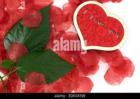 "I love you" wooden puzzle, heart shaped with rose petals Stock Photo