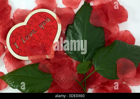 "I love you" wooden puzzle, heart shaped with rose petals Stock Photo