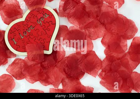 "I love you" wooden puzzle, heart shaped with rose petals Stock Photo