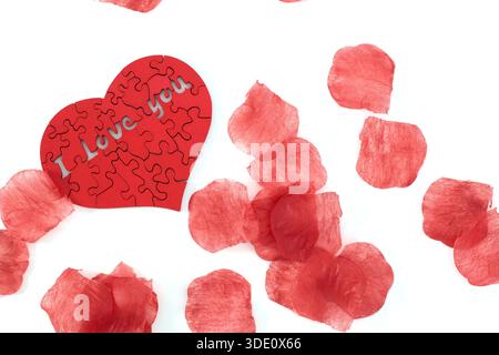 "I love you" wooden puzzle, heart shaped with rose petals Stock Photo