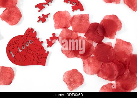 "I love you" wooden puzzle, heart shaped with rose petals Stock Photo