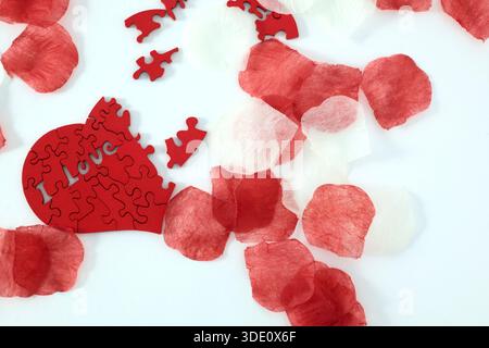 "I love you" wooden puzzle, heart shaped with rose petals Stock Photo