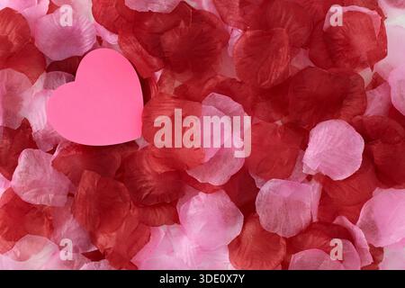 Heart shape sticky notes laying on rose petals Stock Photo