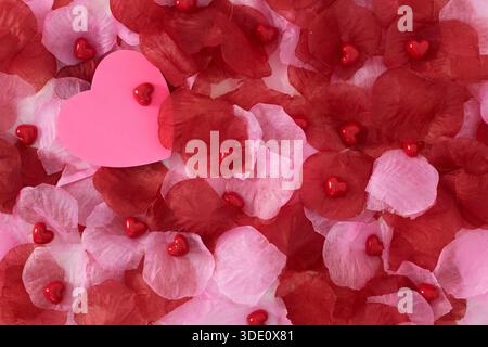 Heart shape sticky notes laying on rose petals Stock Photo