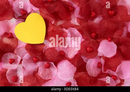 Heart shape sticky notes laying on rose petals Stock Photo