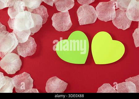 Heart shape sticky notes laying on rose petals Stock Photo
